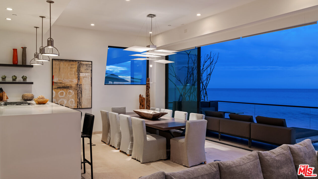 25250 Malibu Road Malibu, CA 90265 - Photo 58 of 69 a kitchen with stainless steel appliances kitchen island granite countertop a table chairs in it and a wooden floors