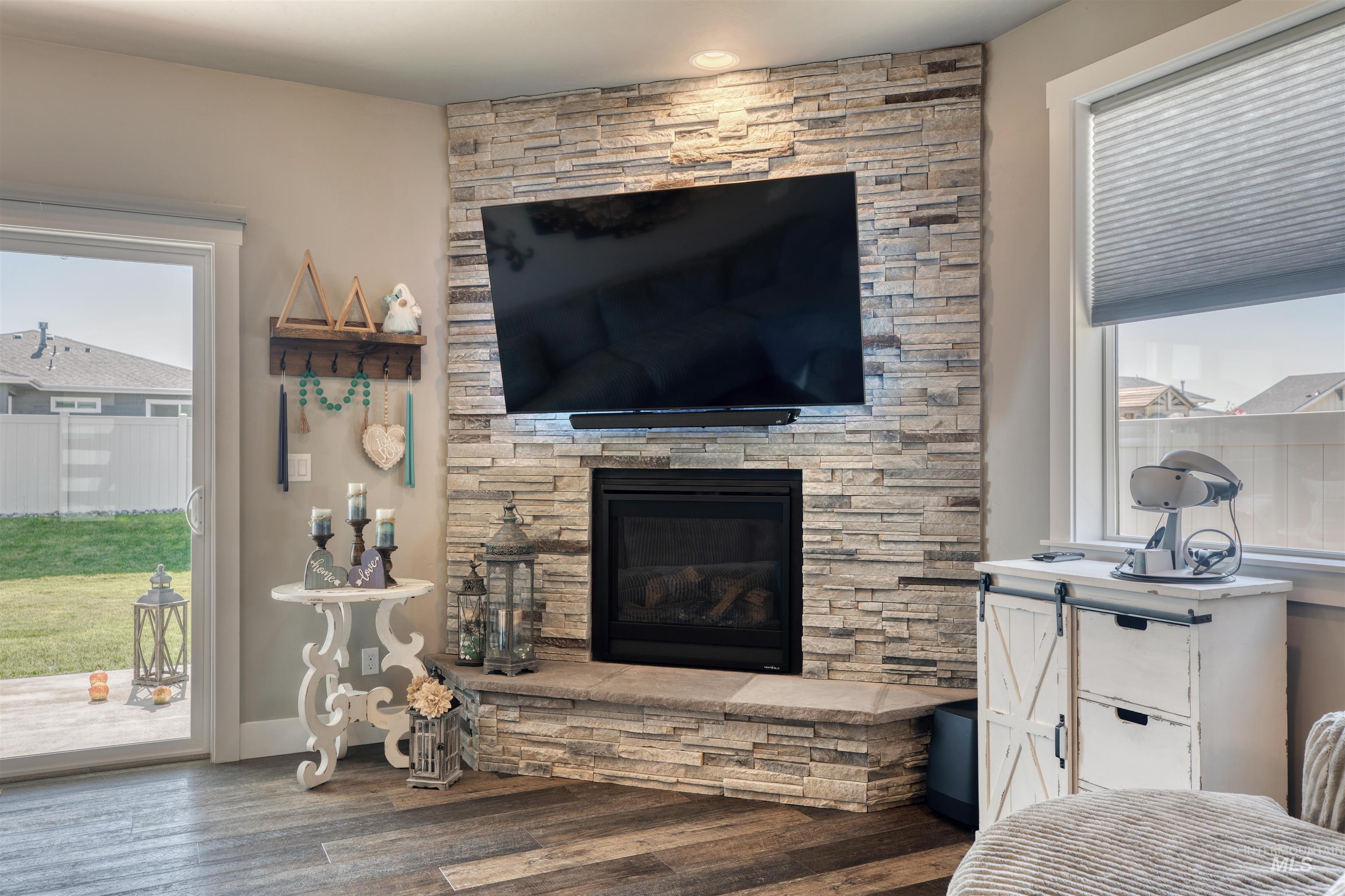 11913 West Piazza Street Nampa, ID 83686 - Photo 12 of 50 Living area with wood finished floors and a stone fireplace