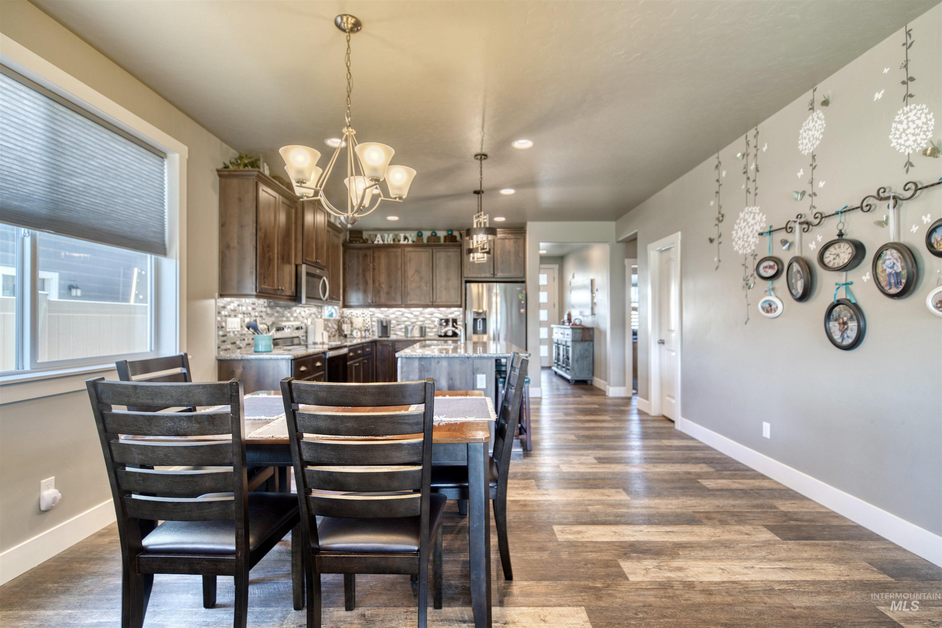 11913 West Piazza Street Nampa, ID 83686 - Photo 14 of 50 Dining room featuring dark wood-style floors, a chandelier, and recessed lighting
