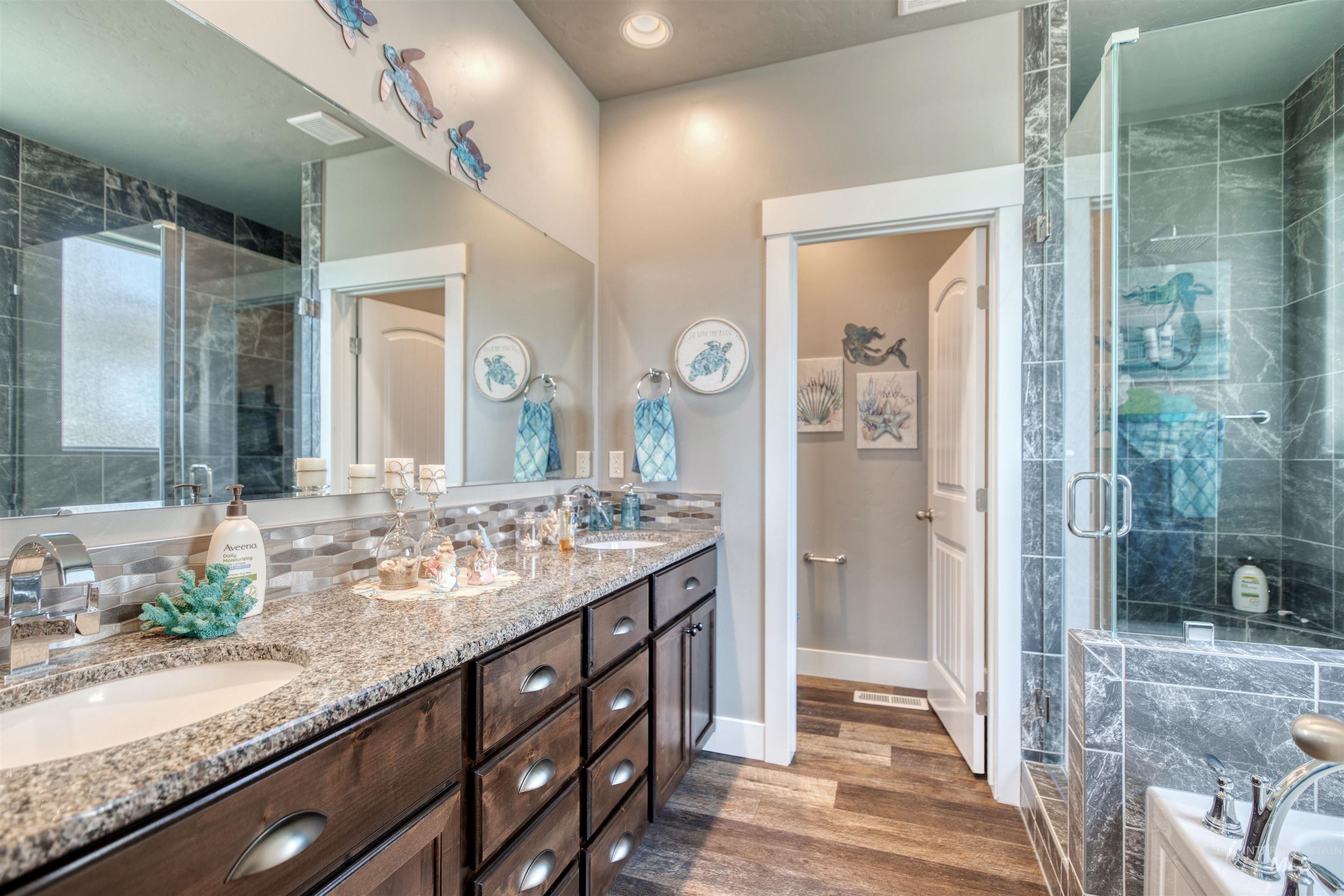 11913 West Piazza Street Nampa, ID 83686 - Photo 21 of 50 Bathroom with double vanity, a stall shower, dark wood-style floors, a garden tub, and recessed lighting