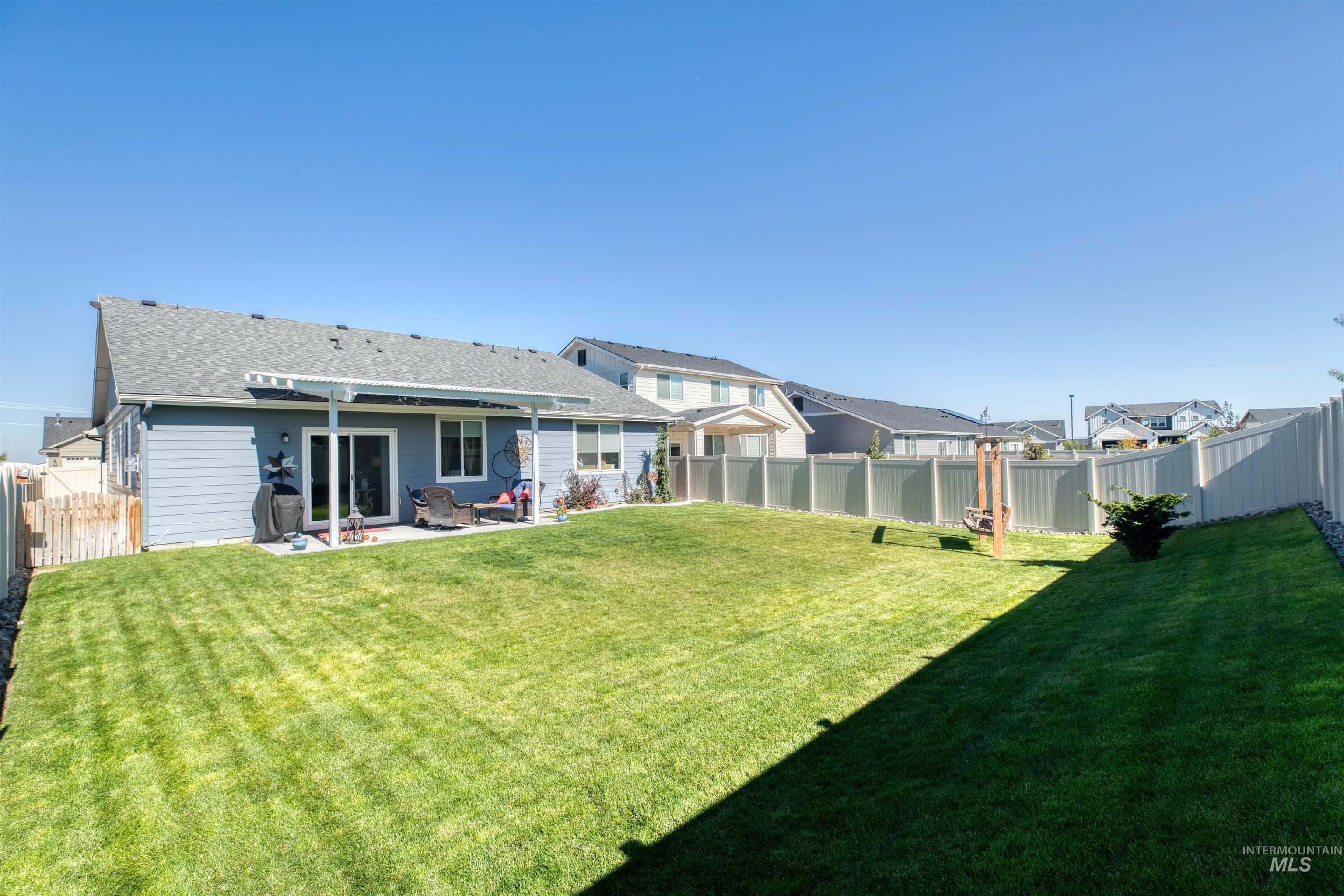 11913 West Piazza Street Nampa, ID 83686 - Photo 27 of 50 Back of house with a fenced backyard, a patio area, and a shingled roof