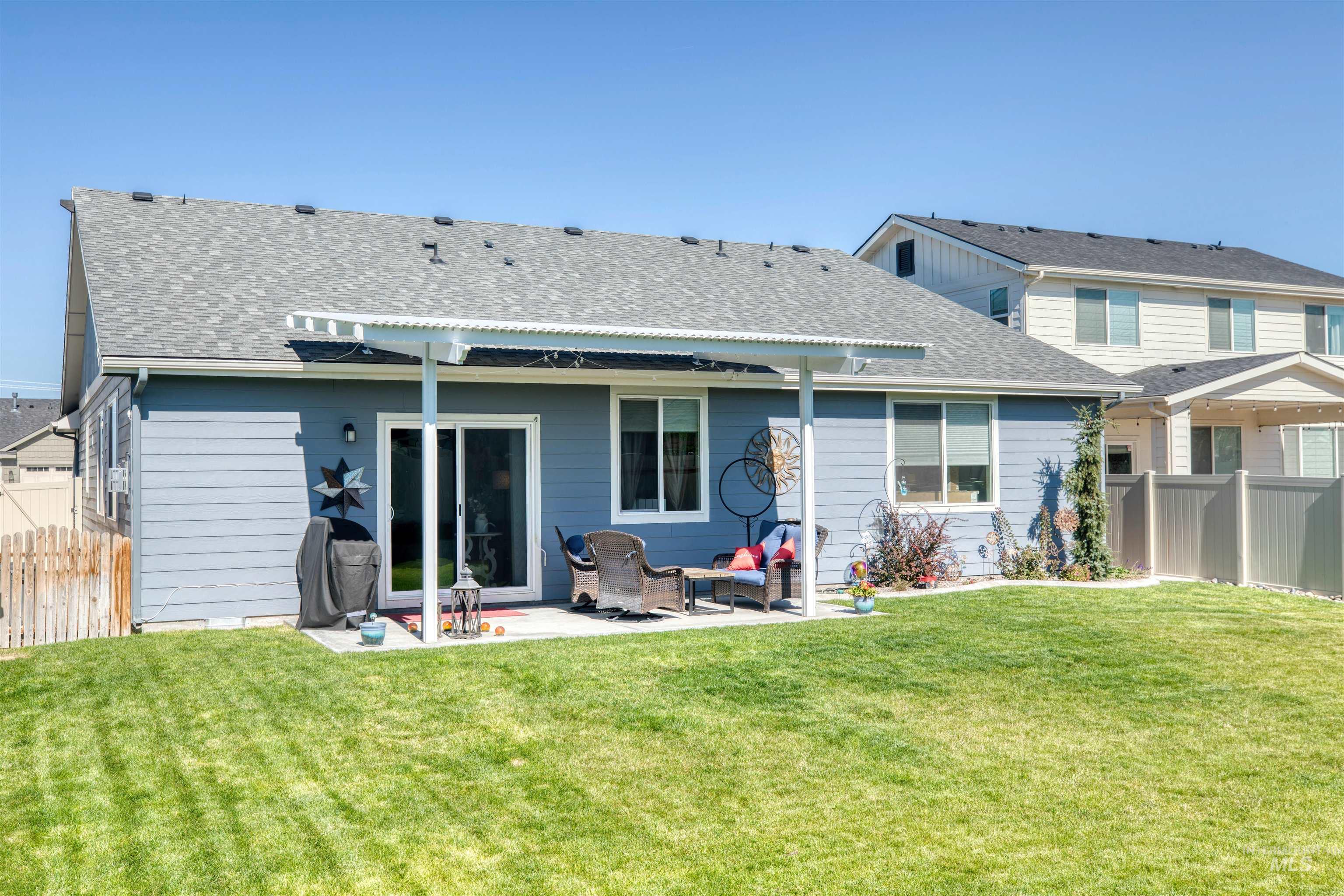 11913 West Piazza Street Nampa, ID 83686 - Photo 28 of 50 Rear view of house with a fenced backyard, a shingled roof, and a patio area