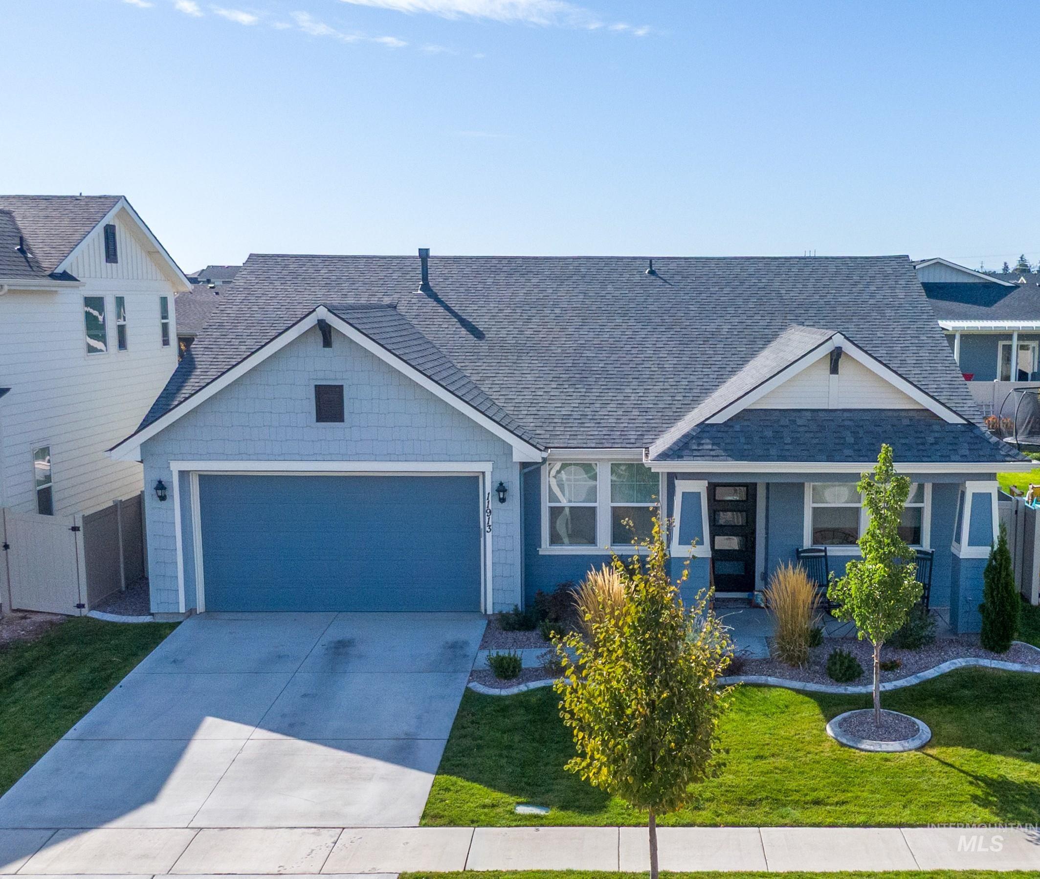 11913 West Piazza Street Nampa, ID 83686 - Photo 44 of 50 Craftsman-style home with roof with shingles, driveway, and an attached garage