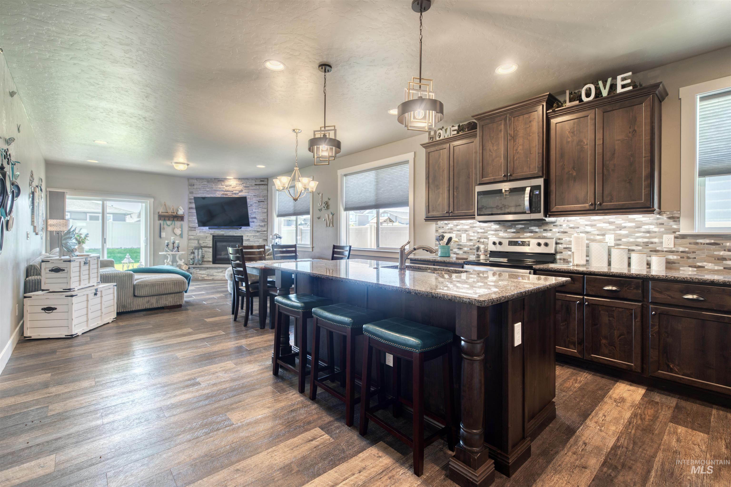 11913 West Piazza Street Nampa, ID 83686 - Photo 50 of 50 Kitchen featuring open floor plan, light stone countertops, plenty of natural light, a textured ceiling, and recessed lighting