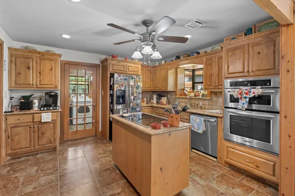 a kitchen with stainless steel appliances granite countertop a stove a sink and a microwave
