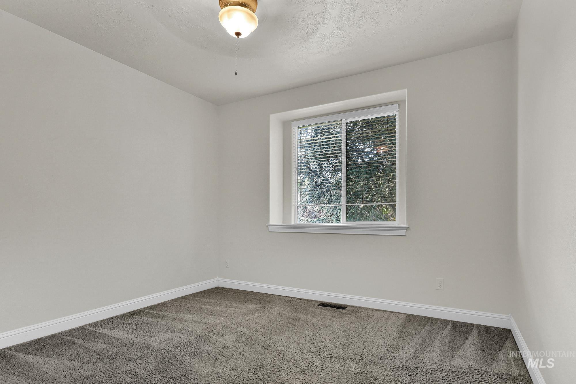 2172 West Cedar Grove Street Meridian, ID 83646 - Photo 21 of 49 Carpeted room featuring a single window with horizontal blinds, white baseboards, and a ceiling-mounted light fixture