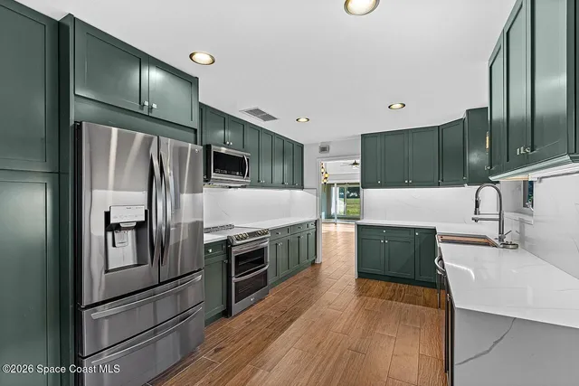 a kitchen with stainless steel appliances and wooden cabinets