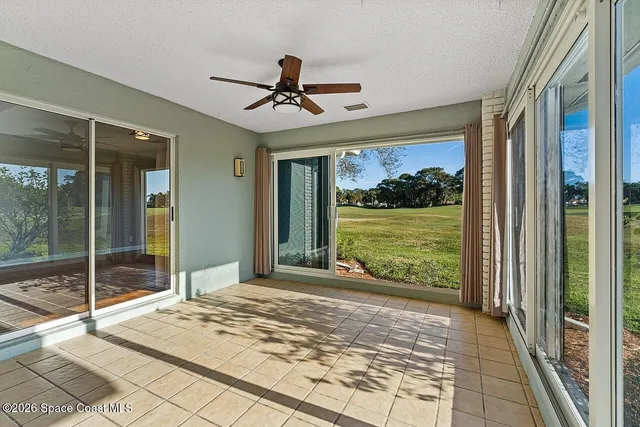 a view of a room with a large window and wooden floor