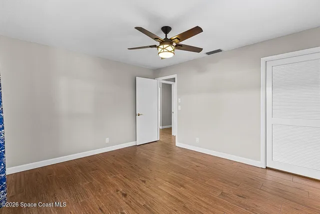 a view of an empty room with wooden floor