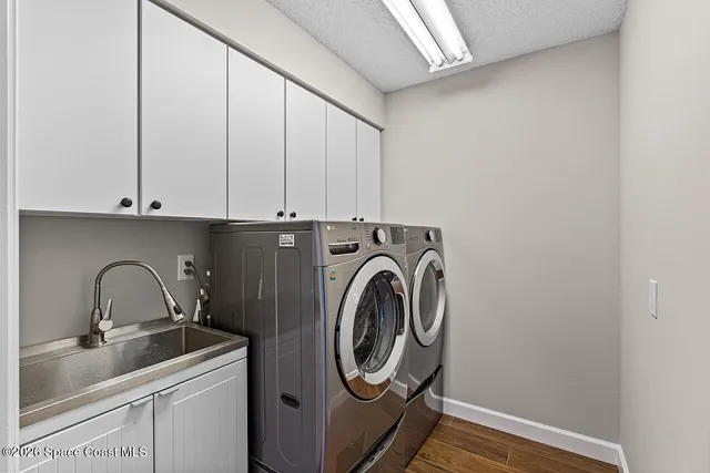 a utility room with sink dryer and washer