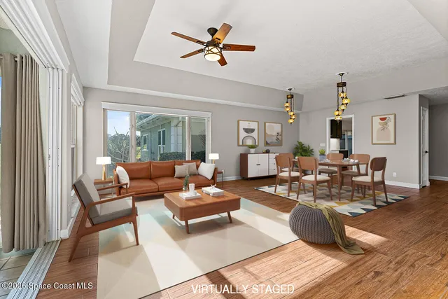 a living room with furniture a rug chandelier and a window
