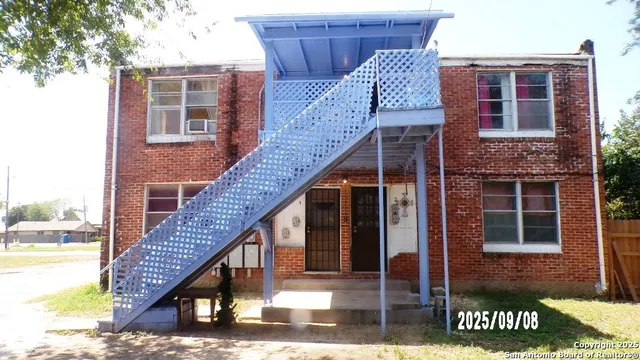 a view of a house with wooden deck and furniture