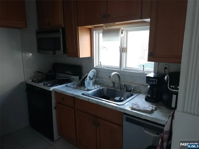 a kitchen with a sink a counter space cabinets and a window