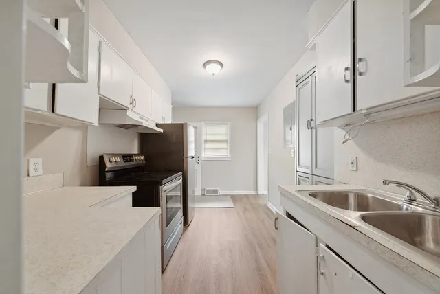 a kitchen with a sink a stove and cabinets