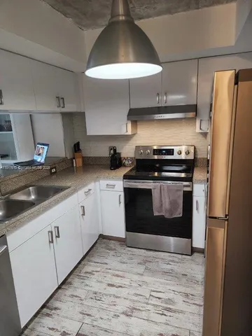 a kitchen with stainless steel appliances a stove a refrigerator and a sink