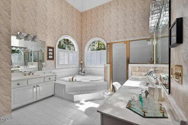a spacious bathroom with a granite countertop tub a double vanity sink and a large mirror