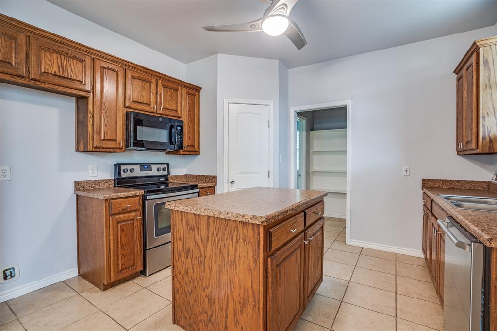 1503 Cherry Street Gainesville, TX 76240 - Photo 6 of 20 a kitchen with stainless steel appliances granite countertop a stove top oven a sink dishwasher and a refrigerator