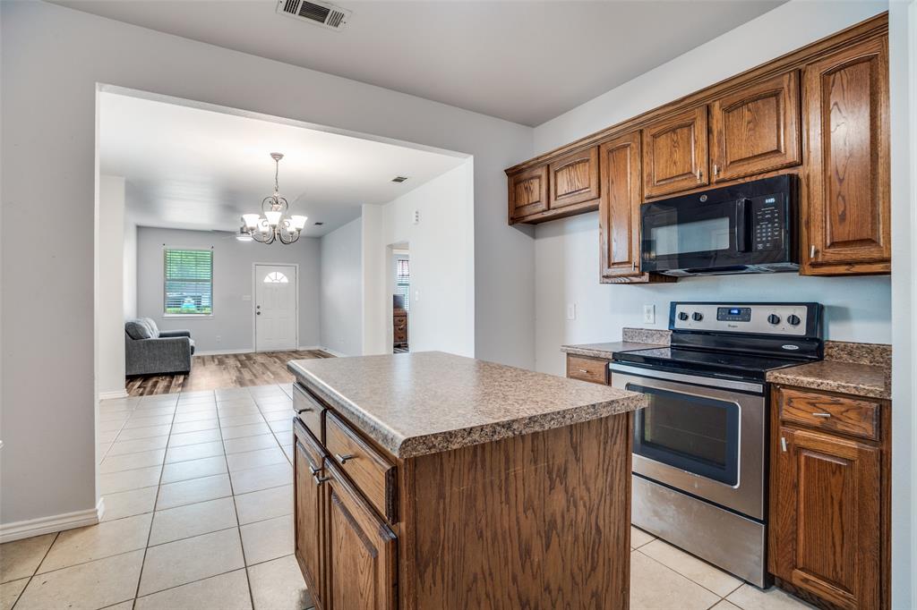 1503 Cherry Street Gainesville, TX 76240 - Photo 8 of 20 a kitchen with a stove a sink and a microwave