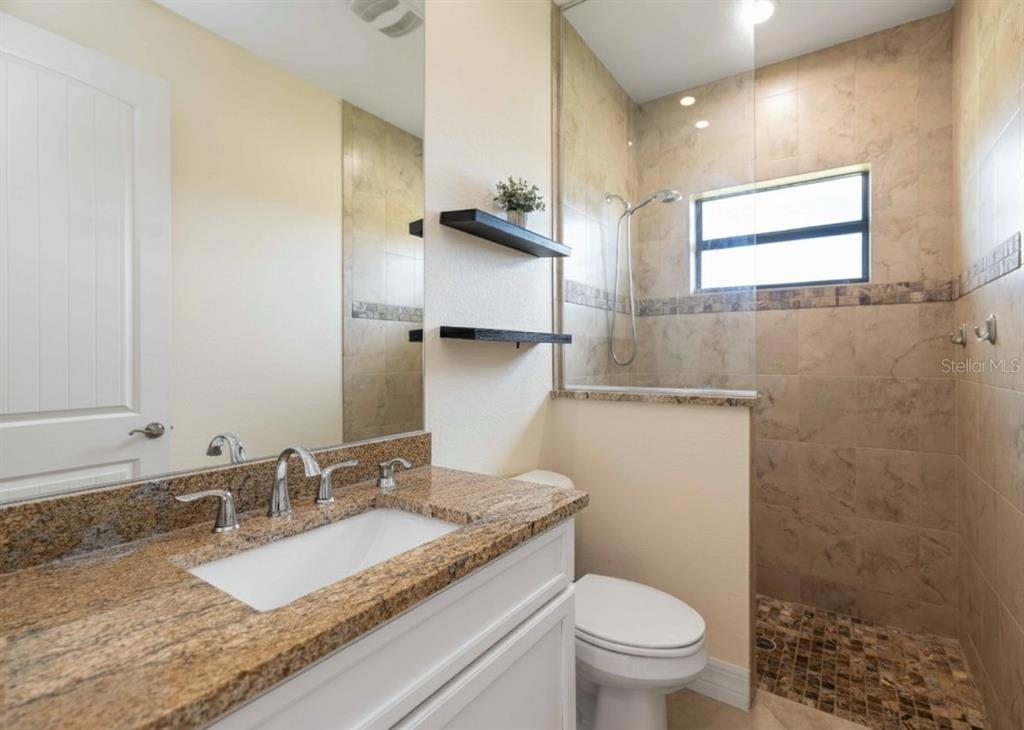 11626 Bridle Path Lane Placida, FL 33946 - Photo 8 of 51 a bathroom with a granite countertop sink a toilet and a mirror