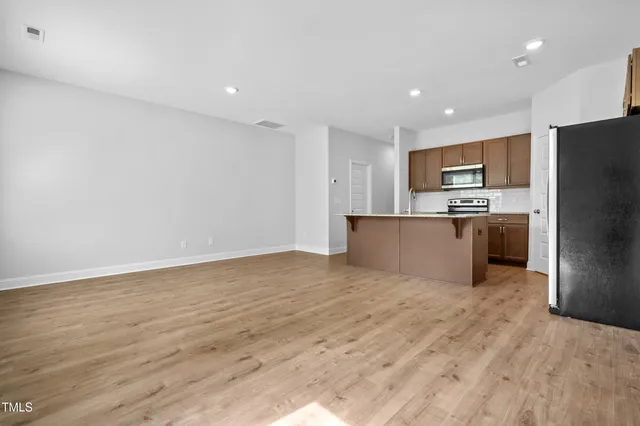 a large kitchen with stainless steel appliances a refrigerator and a stove top oven