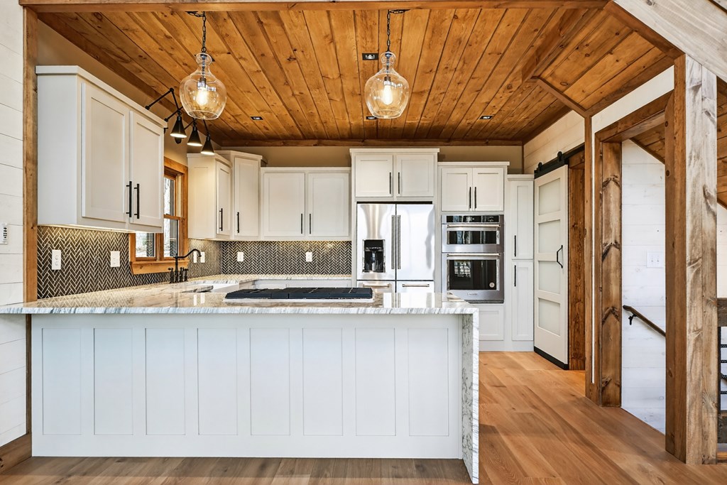 21 Mountain Trace Cherry Log, GA 30522 - Photo 12 of 49 a kitchen with stainless steel appliances granite countertop a refrigerator a sink dishwasher a stove and white countertops with wooden floor