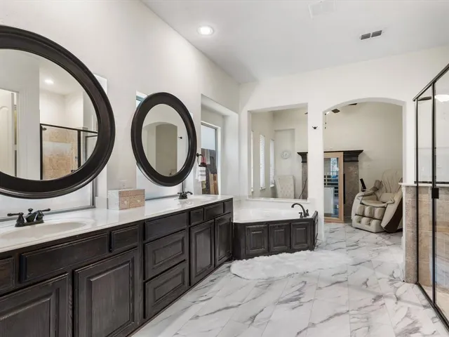 a spacious bedroom with a large bed and a chandelier