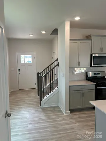 a kitchen with granite countertop a refrigerator and a stove top oven