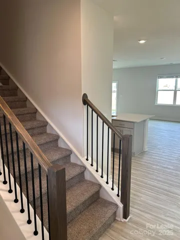 a view of staircase with railing and white walls