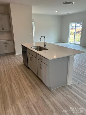 a kitchen with a sink cabinets and wooden floor