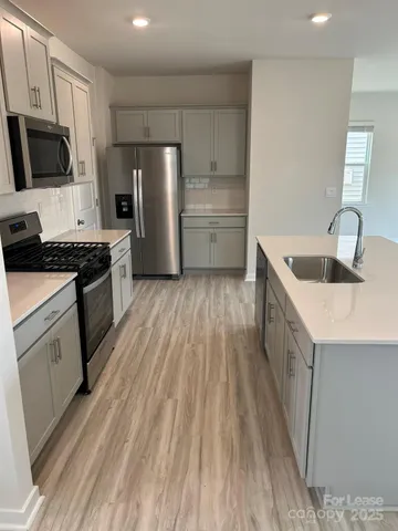 a kitchen with refrigerator a stove a sink and a microwave