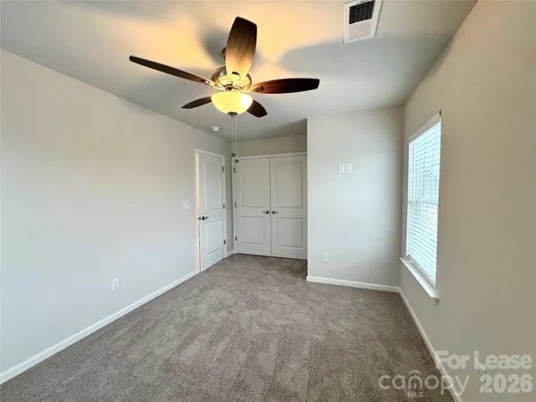 an empty room with a window and a fan