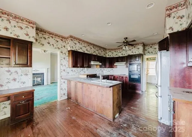 a kitchen with kitchen island stainless steel appliances a sink stove top oven and cabinets