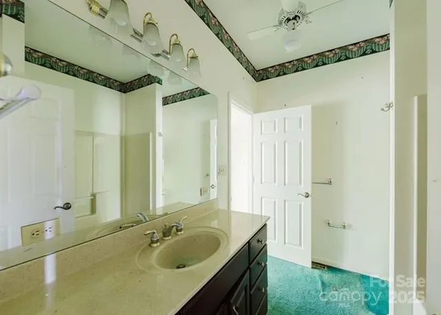 a bathroom with a granite countertop sink a mirror and shower