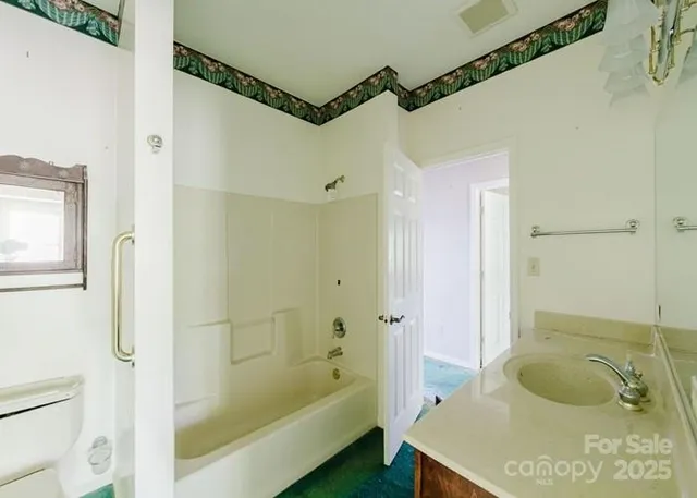 a bathroom with a tub shower sink and mirror