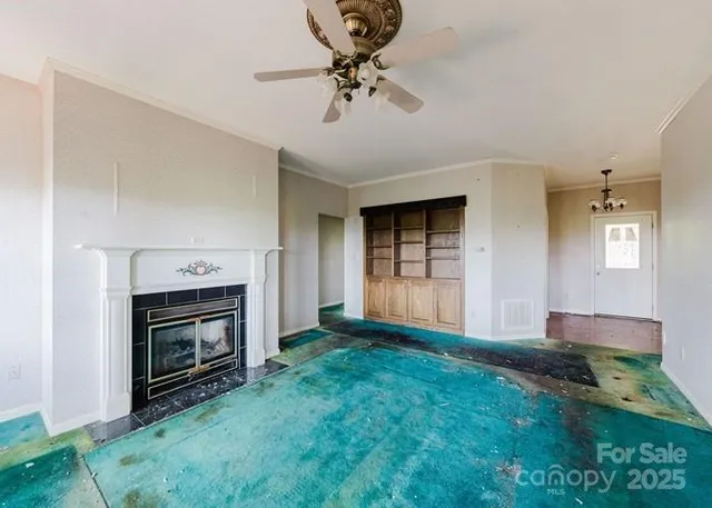 a view of an empty room with window and fireplace