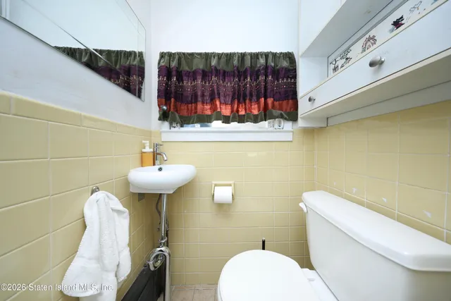 a bathroom with a sink a toilet and mirror