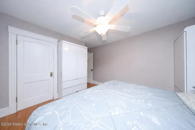 a view of a bedroom with a bed and a chandelier fan