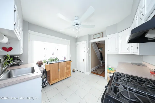 a kitchen with granite countertop a sink stove and refrigerator