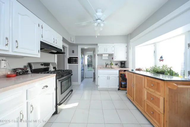 a kitchen with kitchen island granite countertop a sink counter top space appliances and cabinets