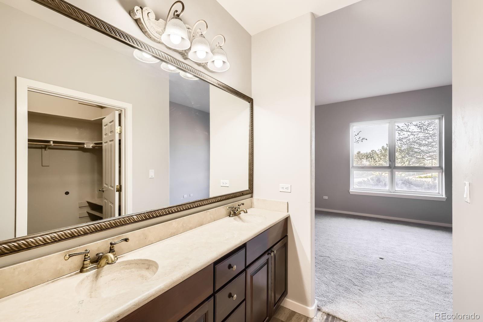 4875 South Monaco Street, Unit 103 Denver, CO 80237 - Photo 13 of 44 a bathroom with a sink a large mirror and a bathtub