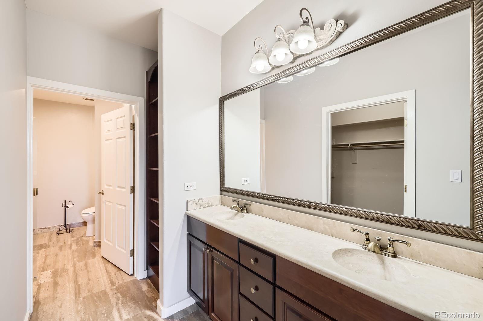 4875 South Monaco Street, Unit 103 Denver, CO 80237 - Photo 14 of 44 a bathroom with a double vanity sink and a mirror