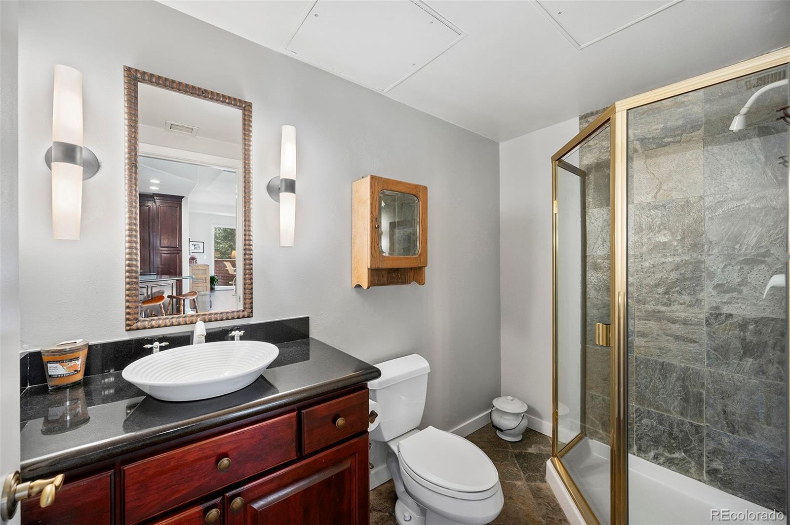 4875 South Monaco Street, Unit 103 Denver, CO 80237 - Photo 18 of 44 a bathroom with a sink a toilet a mirror and shower