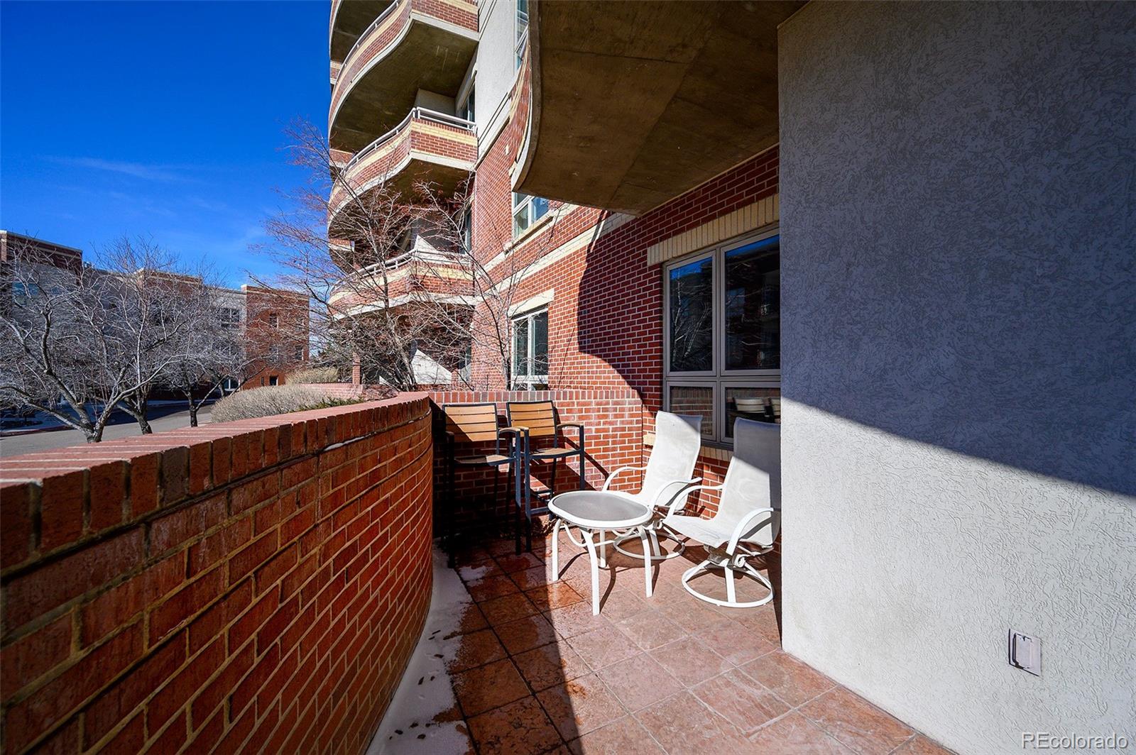 4875 South Monaco Street, Unit 103 Denver, CO 80237 - Photo 22 of 44 a balcony with chairs and wooden floor