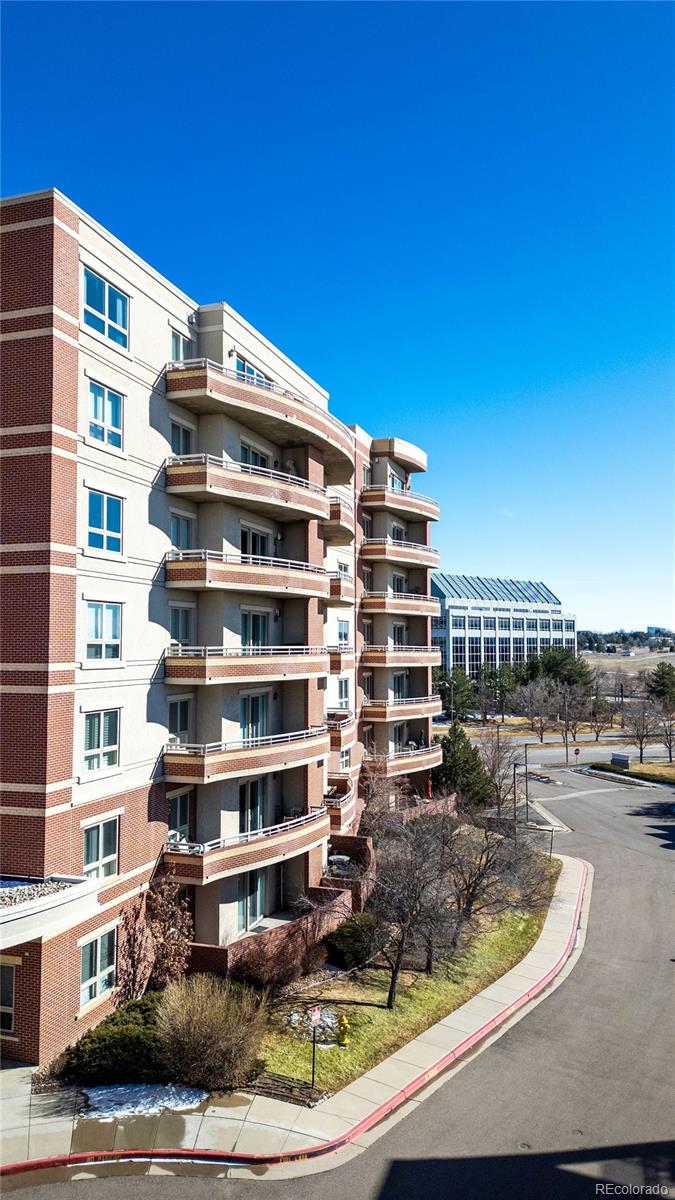4875 South Monaco Street, Unit 103 Denver, CO 80237 - Photo 33 of 44 a view of a tall building with a swimming pool and lawn chairs