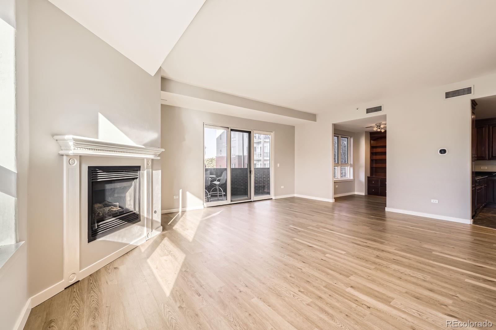 4875 South Monaco Street, Unit 103 Denver, CO 80237 - Photo 8 of 44 wooden floor fireplace and natural light in room