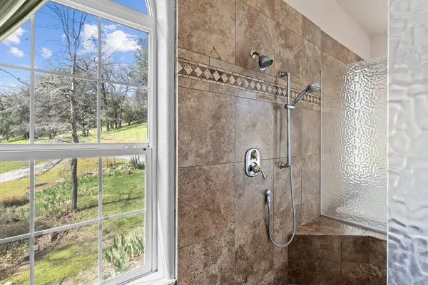 a spacious bathroom with a tub and a large window