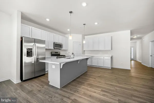 a large kitchen with stainless steel appliances granite countertop a stove top oven a refrigerator a sink and a microwave