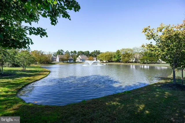 a view of a lake with a yard and large trees