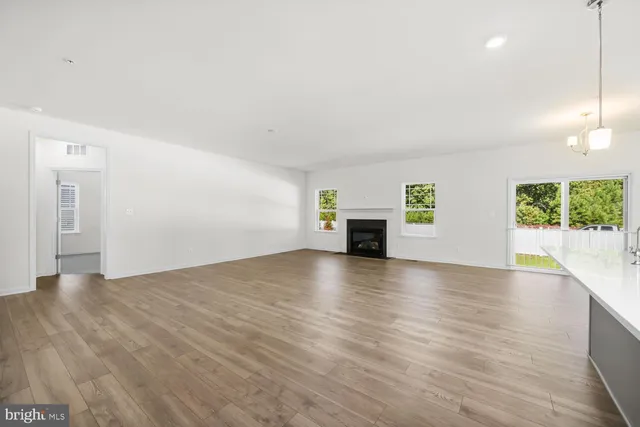 a view of empty room with wooden floor and window