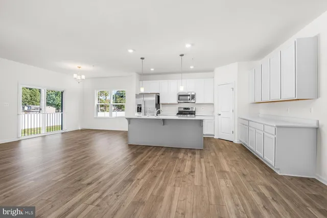 a large white kitchen with wooden floors and white walls
